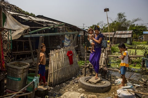 In the districts where we work in Myanmar, most of the huts have bamboo floors, wooden poles and galvanised steel roofs dotted with holes. In front of a hut, a mother carries a baby in her arms. Around her, a boy and a girl step over rubbish.