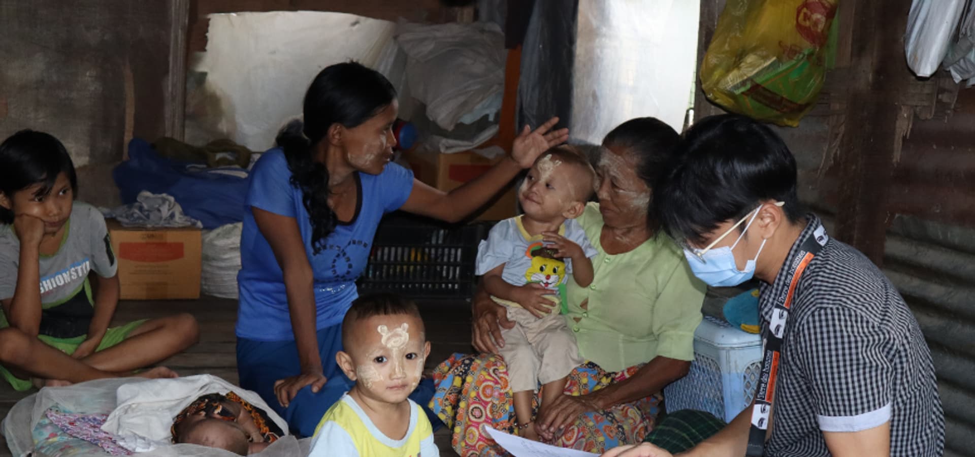 Familie in prekären Verhältnissen in Myanmar und Tdh Staff