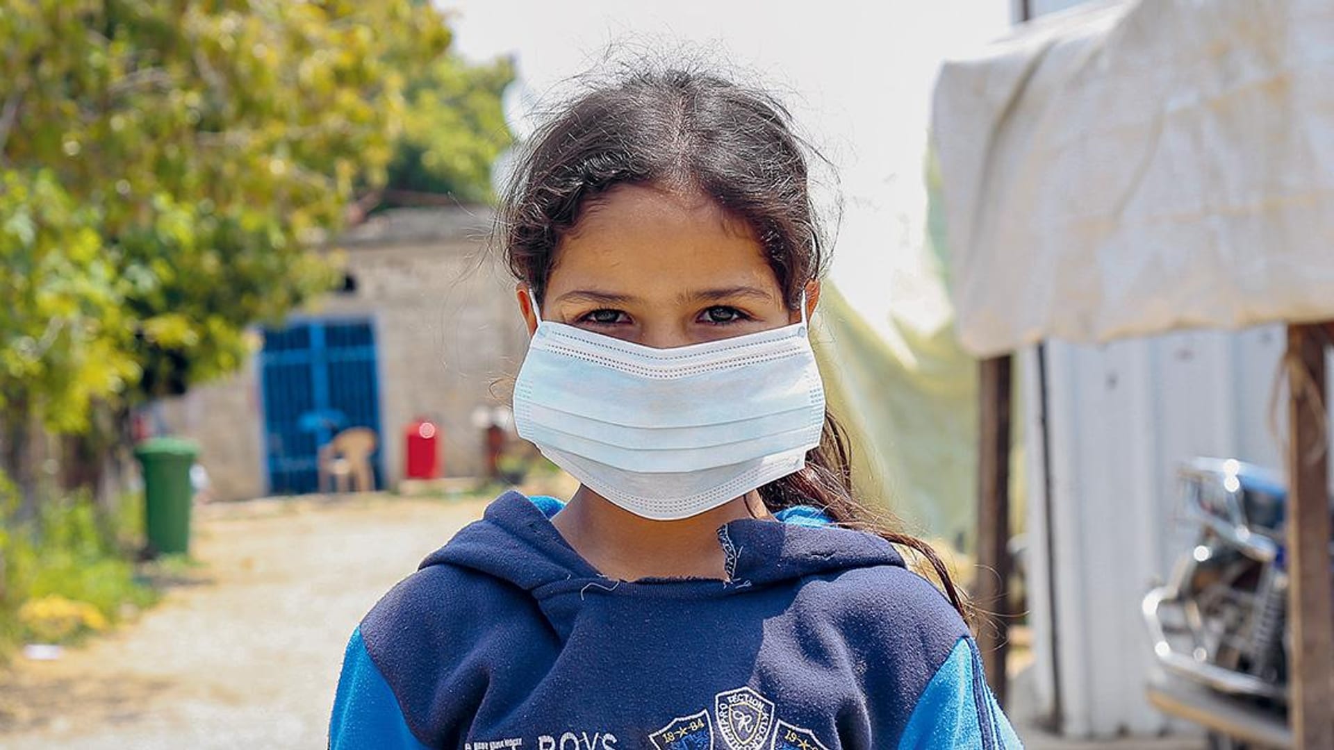 fille réfugiée avec un masque à cause du Covid-19