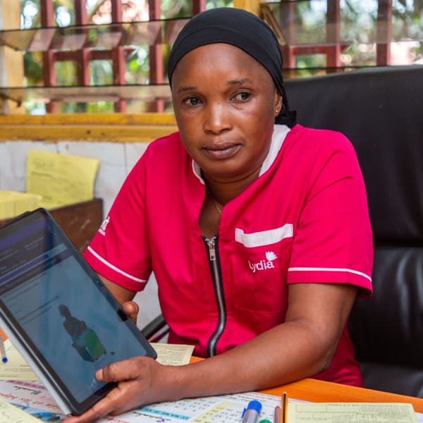 A midwife shows information displayed on a tablet.