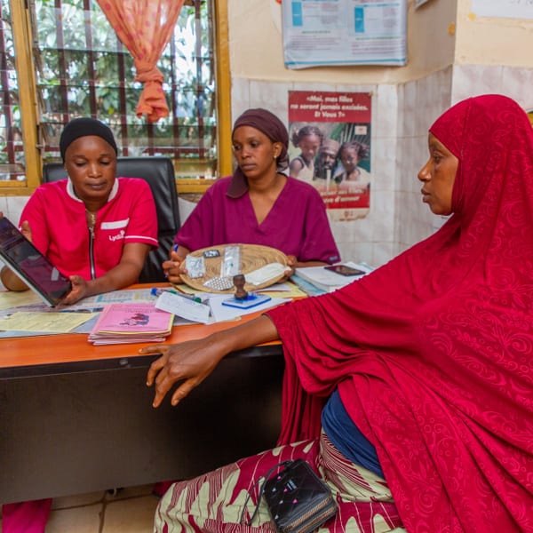 In consultation, Kadiatou sits opposite two midwives.