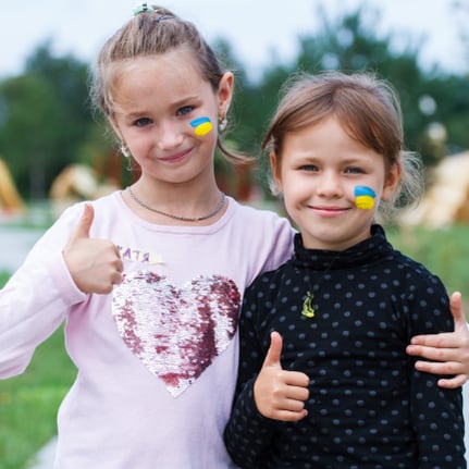 Zwei Mädchen nehmen an Aktivitäten für vertriebene Kinder aus der Ukraine teil.