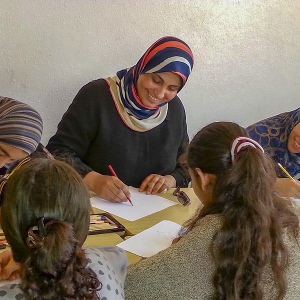 Khitam pendant une activité de coloriage avec des filles.