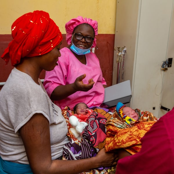 Midwife Marguerite Yama Camara talks to a mother who has just given birth to twins.