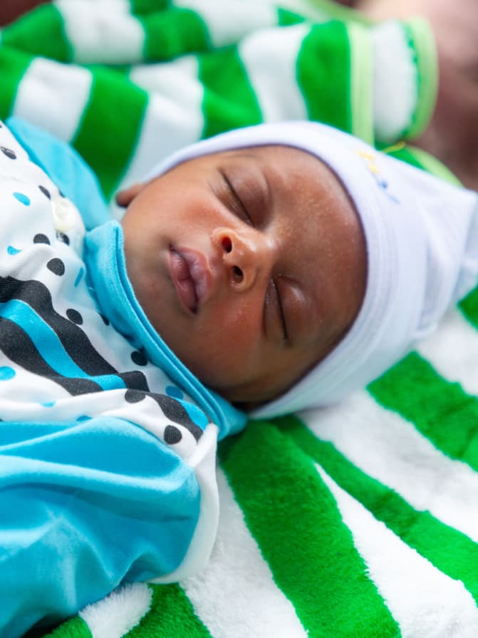 Sleeping newborn lying on a blanket.